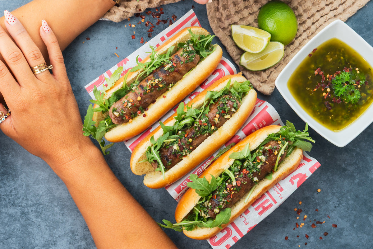 “HECK! Steak & Butter Heckdogs in toasted brioche rolls topped with chimichurri, easy BBQ sausage recipe.”