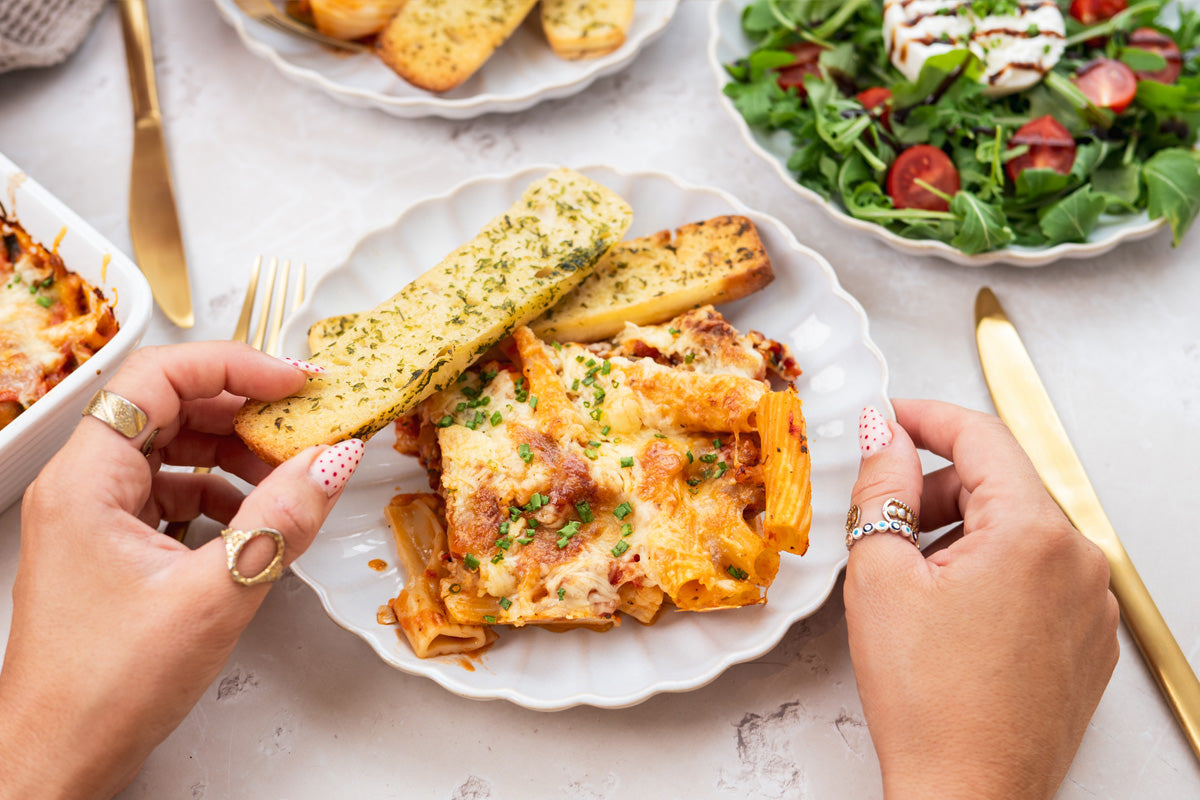 HECK! Pork & Cheddar sausage pasta bake with golden melted cheese and parsley garnish