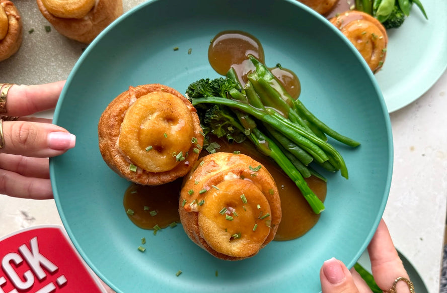 Smiley face Yorkshire puddings served with greens and gravy.